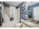 Bathroom featuring vanity, shower and decorative shelving at 750 Evelynton Loop, The Villages, FL 32162