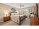 Bedroom with neutral walls, a ceiling fan, and natural wood furniture at 750 Evelynton Loop, The Villages, FL 32162