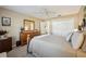 Bedroom with neutral walls, a ceiling fan, and natural wood furniture at 750 Evelynton Loop, The Villages, FL 32162