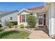 Inviting front entrance with colorful landscaping and a decorative red front door at 750 Evelynton Loop, The Villages, FL 32162