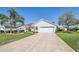 Charming single-Gathering home with a paved driveway, red roof, lush lawn, and mature landscaping at 750 Evelynton Loop, The Villages, FL 32162