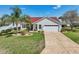 Beautiful home featuring manicured lawn, brick-lined garden, and a paver driveway at 750 Evelynton Loop, The Villages, FL 32162