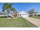 Picture-perfect home featuring a lush lawn, paver driveway, and charming curb appeal at 750 Evelynton Loop, The Villages, FL 32162