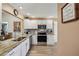 Bright kitchen with granite counters, stainless steel appliances, and modern fixtures at 750 Evelynton Loop, The Villages, FL 32162