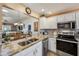 Bright kitchen featuring granite countertops, stainless steel appliances, and tile backsplash at 750 Evelynton Loop, The Villages, FL 32162