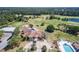 Stunning aerial view of a golf course, clubhouse, pool, and surrounding natural landscape at 8051 Saint James Way, Mount Dora, FL 32757