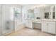 Bright bathroom featuring double sinks, a soaking tub with shower, and white cabinetry, offering a clean aesthetic at 8051 Saint James Way, Mount Dora, FL 32757