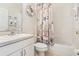 Clean bathroom featuring a vanity, toilet, and a tub with a nautical-themed shower curtain, creating a coastal vibe at 8051 Saint James Way, Mount Dora, FL 32757