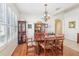 Dining room featuring a hardwood floor, chandelier, and plantation shutters at 8051 Saint James Way, Mount Dora, FL 32757