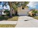 Two-story home with a large tree in the front yard and a two car garage at 8051 Saint James Way, Mount Dora, FL 32757