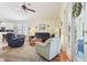 Bright living room featuring comfortable seating, a ceiling fan, and sliding glass doors with a view to the outside at 8051 Saint James Way, Mount Dora, FL 32757