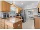 Well-equipped kitchen featuring wooden cabinets, granite countertops, and stainless steel appliances at 841 Eagles Lndg, Leesburg, FL 34748