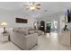 Bright living room featuring a neutral-colored sofa, tile flooring, and sliding glass doors to the lanai at 841 Eagles Lndg, Leesburg, FL 34748