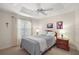 Bedroom with tray ceiling, ceiling fan and window with curtains and views of the neighborhood at 859 Parksville Path, The Villages, FL 32162