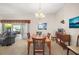 Elegant dining room with a chandelier, seating for six, and sliding door access at 859 Parksville Path, The Villages, FL 32162