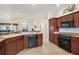 Open-concept kitchen featuring wood cabinetry, a breakfast bar, and modern appliances at 859 Parksville Path, The Villages, FL 32162