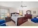 Serene main bedroom with soft lighting, plush carpeting, and a ceiling fan at 859 Parksville Path, The Villages, FL 32162