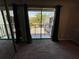 Carpeted bedroom with sliding glass doors lead to a balcony that overlooks lush tropical foliage at 1000 Royal Oak Blvd, Leesburg, FL 34748