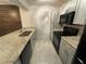 Galley kitchen with granite countertops, stainless steel appliances, and light gray cabinets at 1000 Royal Oak Blvd, Leesburg, FL 34748