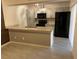 Open concept kitchen with granite counters, stainless steel appliances, gray cabinets, and tiled floor at 1000 Royal Oak Blvd, Leesburg, FL 34748
