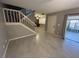 This living room features tile flooring, stairs to upper level, and access to outdoor balcony at 1000 Royal Oak Blvd, Leesburg, FL 34748