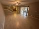 Spacious, light-filled living room with tile flooring, stairs, and access to a backyard patio at 1000 Royal Oak Blvd, Leesburg, FL 34748