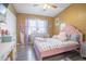 This bedroom features a pink bed frame, grey wood floors, and a ceiling fan at 102 S Sunland Dr, Sanford, FL 32773