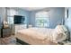 Serene bedroom with light blue walls, window views, and comfortable queen sized bed at 102 S Sunland Dr, Sanford, FL 32773
