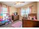 Bright bedroom with two windows, wood-look flooring, and decor at 102 S Sunland Dr, Sanford, FL 32773