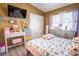 Bedroom boasts a pink bed, desk with cosmetics, and mounted television at 102 S Sunland Dr, Sanford, FL 32773