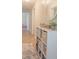 Hallway with storage unit, mirror, neutral color scheme, and view to playroom in this home at 102 S Sunland Dr, Sanford, FL 32773