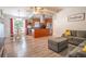 View of the hardwood floors, kitchen, and comfortable sectional in this house's living room at 102 S Sunland Dr, Sanford, FL 32773