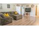 Comfortable living room with wood laminate floors, gray sofa, and fireplace at 102 S Sunland Dr, Sanford, FL 32773