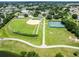 Aerial view of community baseball and tennis fields in a lush green setting with surrounding neighborhood at 11743 Se 174Th Loop, Summerfield, FL 34491