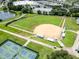 Aerial view of a community baseball and tennis fields, and a nearby pond at 11743 Se 174Th Loop, Summerfield, FL 34491