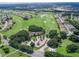 An aerial shot showcasing a golf course, nearby homes, and lush green landscaping at 11743 Se 174Th Loop, Summerfield, FL 34491