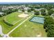 Aerial view of community baseball and tennis fields with surrounding trees and lush greenery at 11743 Se 174Th Loop, Summerfield, FL 34491