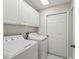 Practical laundry room with washer, dryer, and ample storage cabinets at 11743 Se 174Th Loop, Summerfield, FL 34491