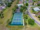 Aerial view of well-maintained tennis courts surrounded by lush landscaping in a quiet neighborhood at 11743 Se 174Th Loop, Summerfield, FL 34491