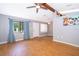 Cozy living room featuring hardwood floors, a beamed vaulted ceiling, and bright natural light coming from a large window at 1306 Vine St, Leesburg, FL 34748