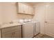 Functional laundry room with modern washer and dryer, cabinetry, and a sink for added convenience at 1435 Jeremy Cir, The Villages, FL 34762