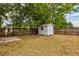 Backyard featuring a wooden fence, small storage shed and trees providing shade at 1515 Washington Ave, Eustis, FL 32726