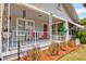 Inviting front porch with decorative railings, a red door, and a cozy seating area at 1515 Washington Ave, Eustis, FL 32726