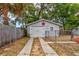 Detached garage with a white door, red star and a concrete driveway at 1515 Washington Ave, Eustis, FL 32726
