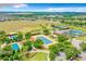 Beautiful aerial view of the community with tennis courts, pools, and a lake at 155 Crepe Myrtle Dr, Groveland, FL 34736