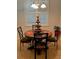 Cozy dining area featuring a round wooden table, four chairs, and plantation shutters at 155 Crepe Myrtle Dr, Groveland, FL 34736