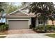 Charming single-story home with a two-car garage, manicured landscaping, and a welcoming entrance at 155 Crepe Myrtle Dr, Groveland, FL 34736