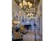 Well-lit hallway with elegant furnishings and a baby grand piano at 155 Crepe Myrtle Dr, Groveland, FL 34736