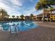 An outdoor pool area with palm trees and lounge chairs at 155 Crepe Myrtle Dr, Groveland, FL 34736