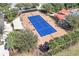 Aerial view of tennis court and shaded seating area in a community at 155 Crepe Myrtle Dr, Groveland, FL 34736